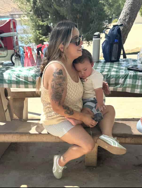Lex, a hospice nurse turned SAHM after leaving nursing, sitting on the floor playing with her baby son