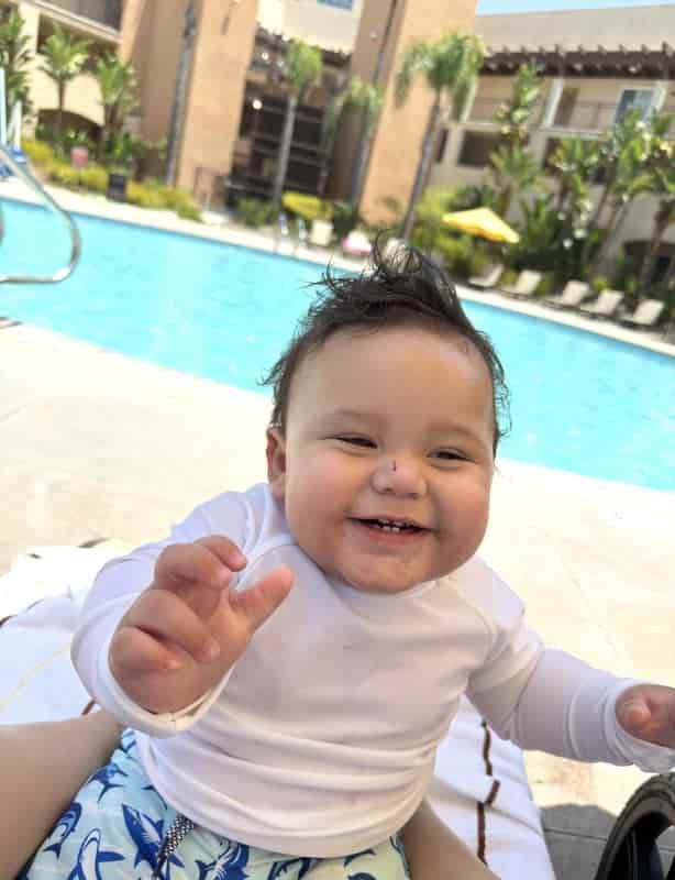 Smiling baby by the pool at a family-friendly hotel in San Diego